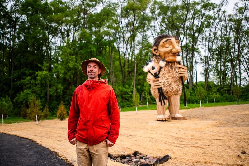 Thomas Dambo stands in front of ‘Mama Rosa’ in Wauwatosa. Photo courtesy of Discover Wauwatosa
