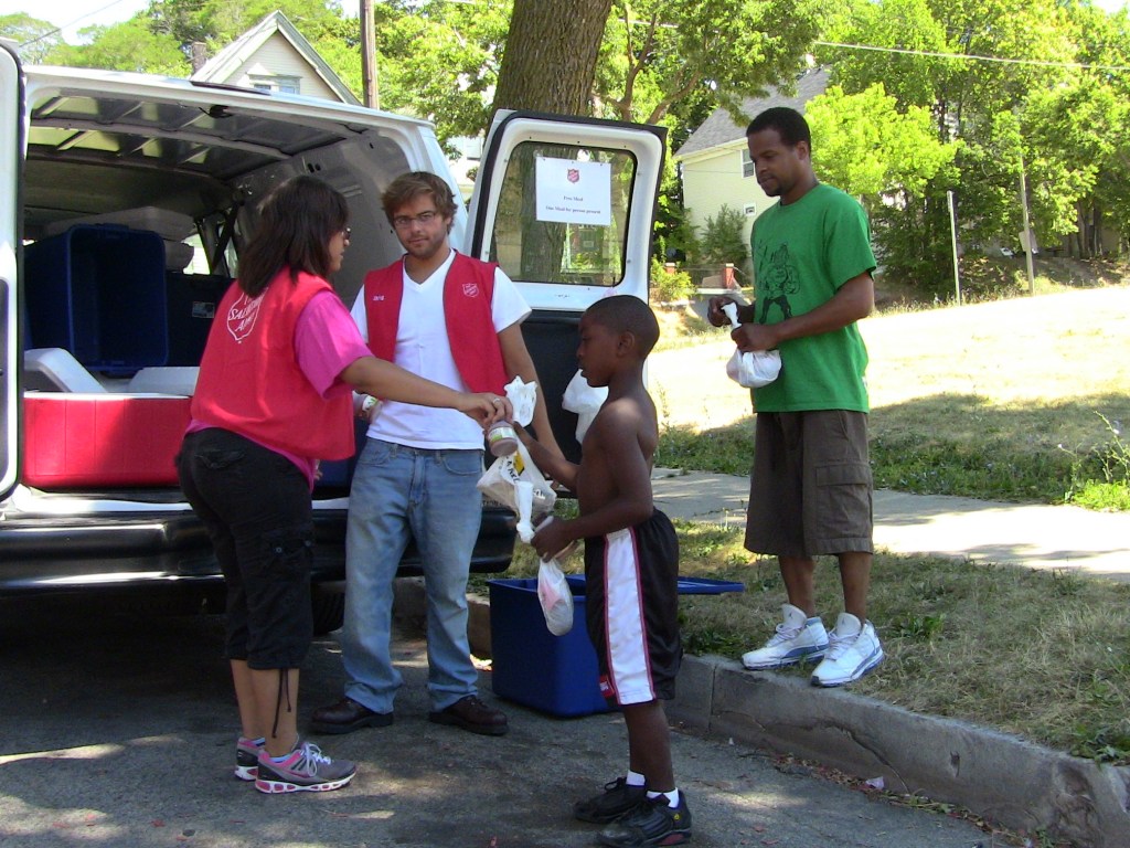 Workers from the Salvation Army’s Feed the Kids summer meal program distribute food to children in Milwaukee’s neighborhoods. (Photo by Carolyn Portner)