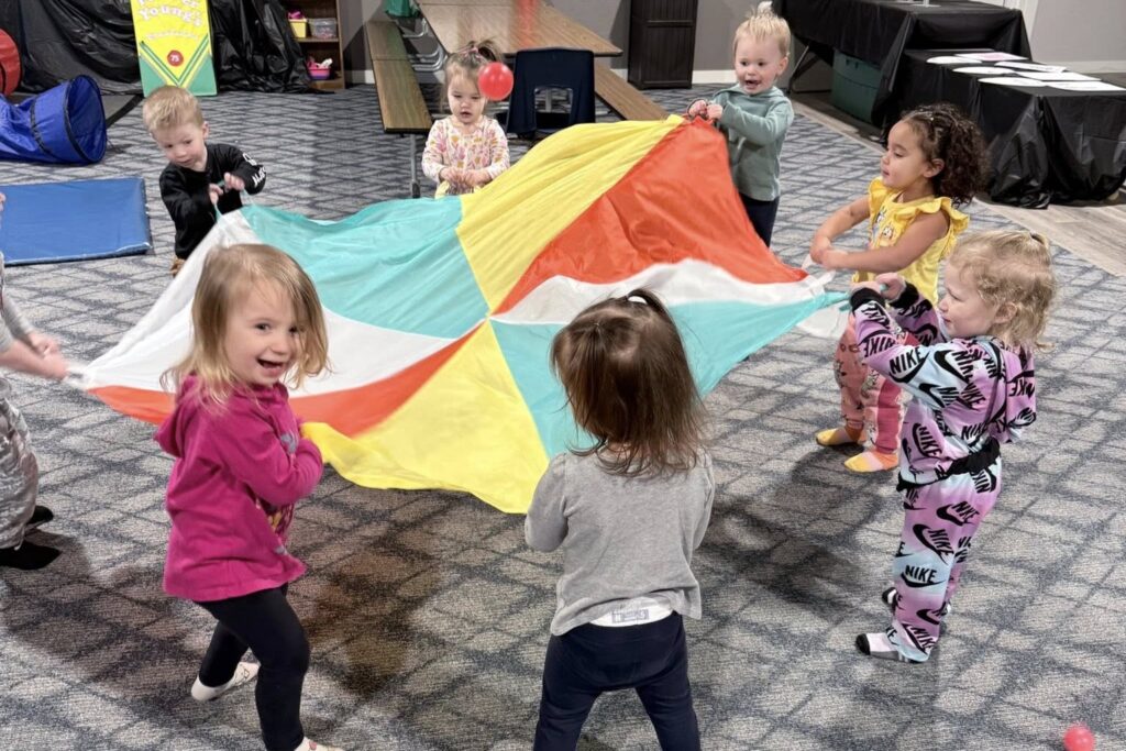 Children at Forever Young childcare center in suburban Green Bay engage in "parachute play." (Photo courtesy of Cindy Veeser)