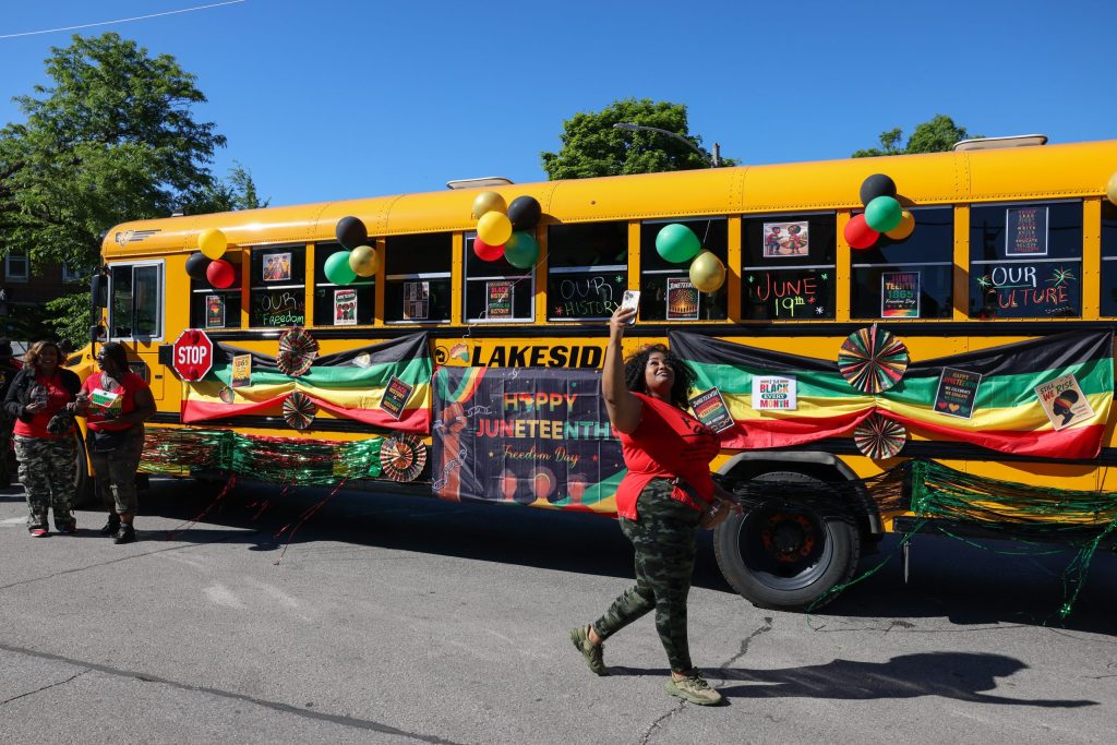 A person walks past a school bus decorated for the 55th Juneteenth Jubilee Parade on Friday, June 19.