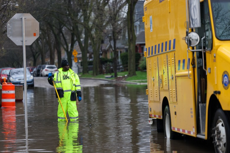 A worker with the Milwaukee Department of Public Works unclogs a storm drain after heavy rainfall caused flooding throughout Milwaukee on April 16. (Photo by Jonathan Aguilar / Milwaukee Neighborhood News Service / CatchLight Local)
