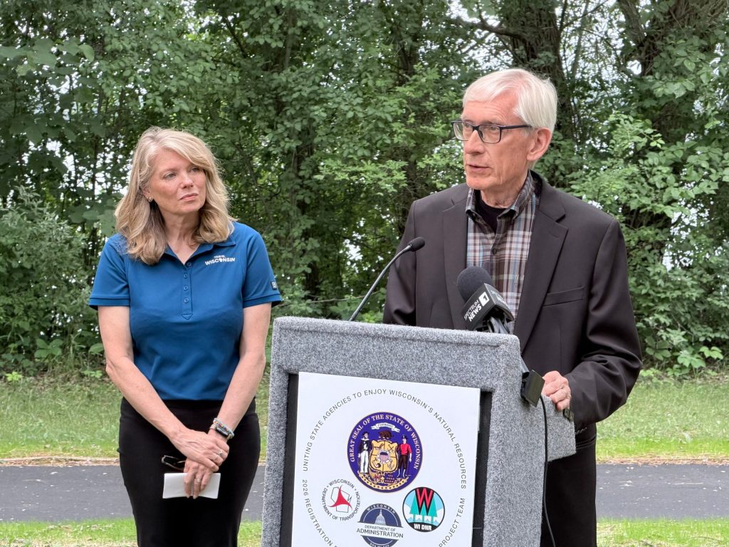 Gov. Tony Evers speaks at a press conference Thursday, June 11 about a new way to purchase state park passes, as Tourism Secretary Anne Sayers looks on. Rob Mentzer/WPR