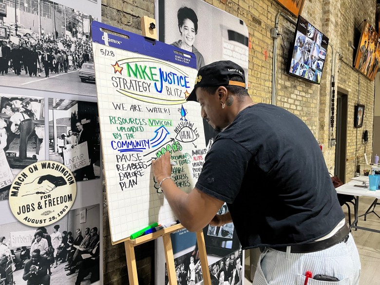 Jene Tate works on illustrating notes during day two of the Milwaukee Justice Strategy Blitz at the Wisconsin Black Historical Society, on May 28. (Photo by Meredith Melland)