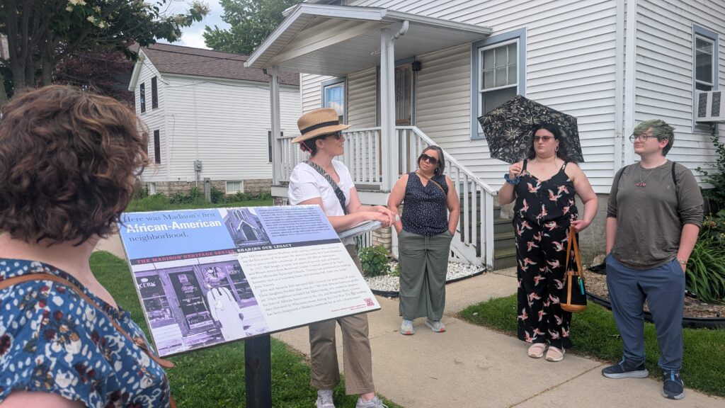 A group of about 12 Wisconsinites gathered on the corner of E. Dayton and N. Blount Street, near a white house that belongs to the Hill family early Thursday evening. (Photo by Baylor Spears/Wisconsin Examiner)