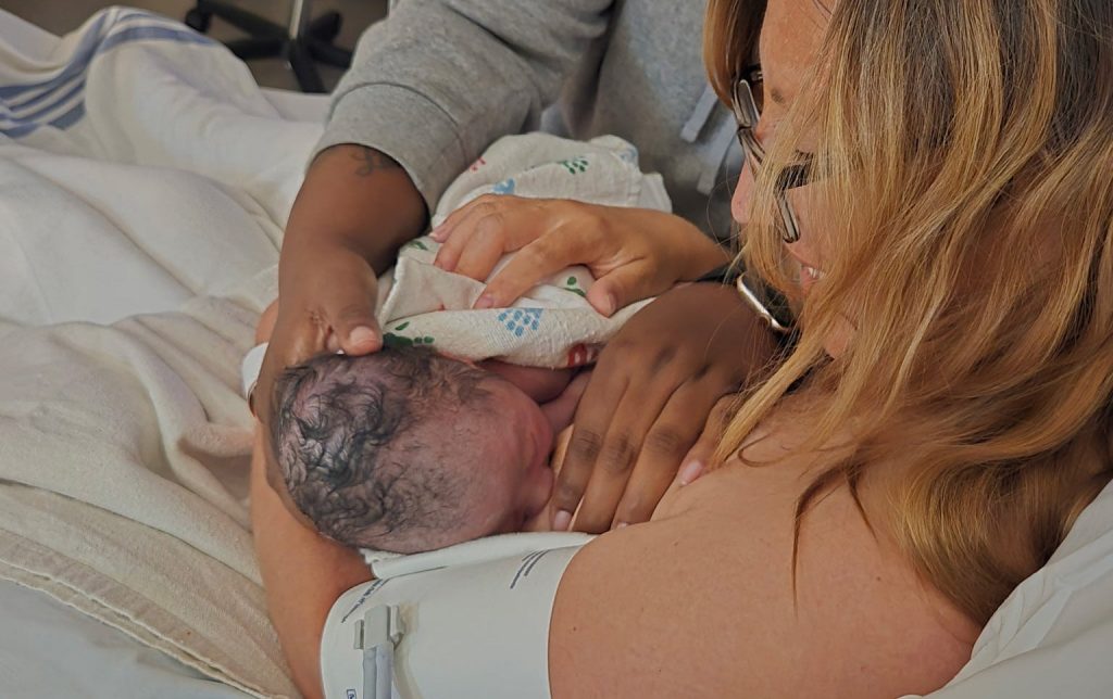 A doula with the Wisconsin Prison Birth Project helps a new incarcerated mother breastfeed her newborn. Photo courtesy of the Ostara Initiative