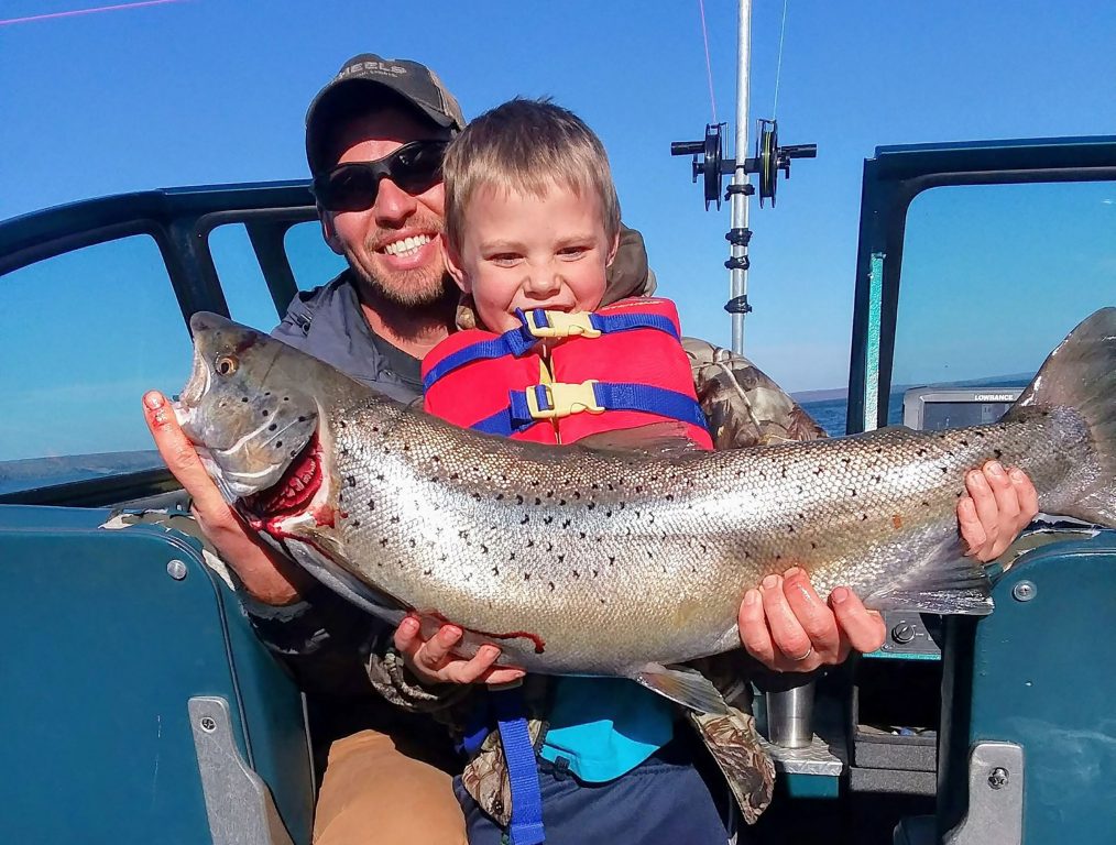 Andrew O’Krueg and his son Nathan hold a brown trout reared at the Brule or Les Voigt fish hatcheries. Darren Miller/Wisconsin DNR