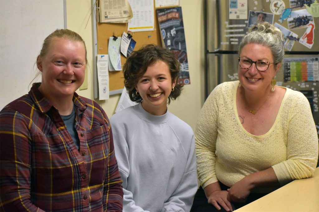 From left to right: Kirsten Rhude, Callie Grones and Deanna Erickson at the offices of the Lake Superior National Estuarine Research Reserve in Superior. Callie Grones is being honored as an AmeriCorps Member of the Year during the Governor’s Service Awards. Her position was temporarily terminated when the Trump administration canceled grant funding for AmeriCorps in 2025. Danielle Kaeding/WPR