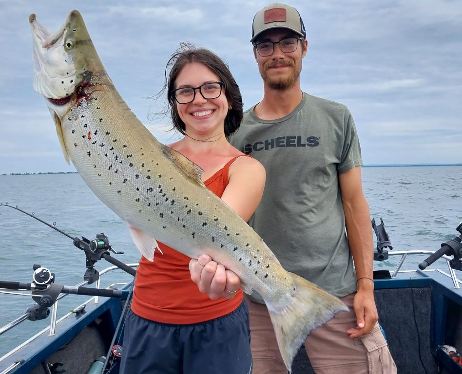 Rachel Niemi, along with Tyler Miller, shows off a brown trout reared at either the Brule or Les Voigt fish hatcheries. Darren Miller/Wisconsin DNR