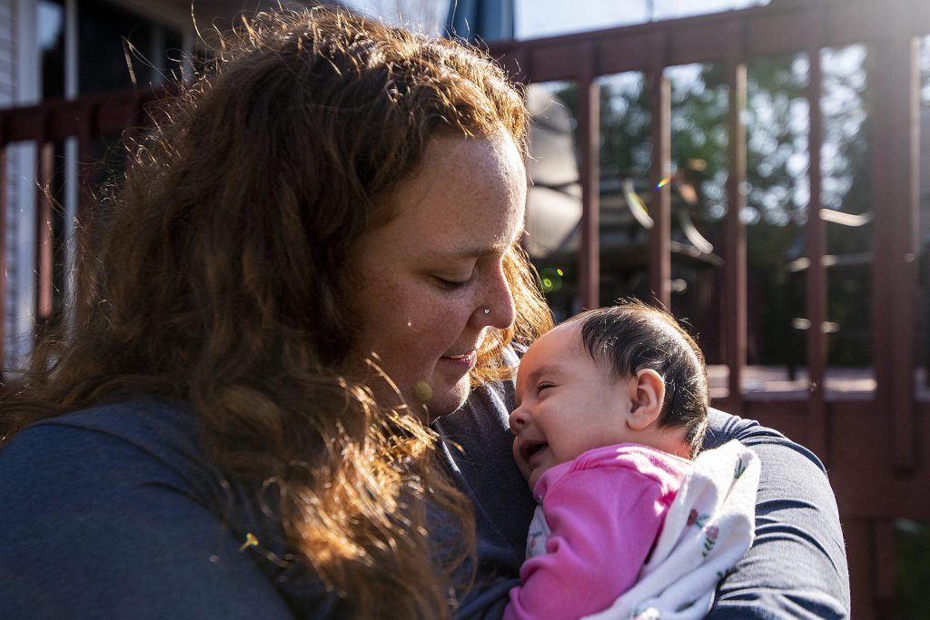 Leah De Gabriel holds her infant daughter Aubree on Nov. 6, 2021, in Madison, Wis. De Gabriel said with all the changes going on in a woman’s body after childbirth, returning to work too soon can be really challenging. “I don’t think anybody benefits when mothers have to go back before they’re ready,” she said. Angela Major/WPR