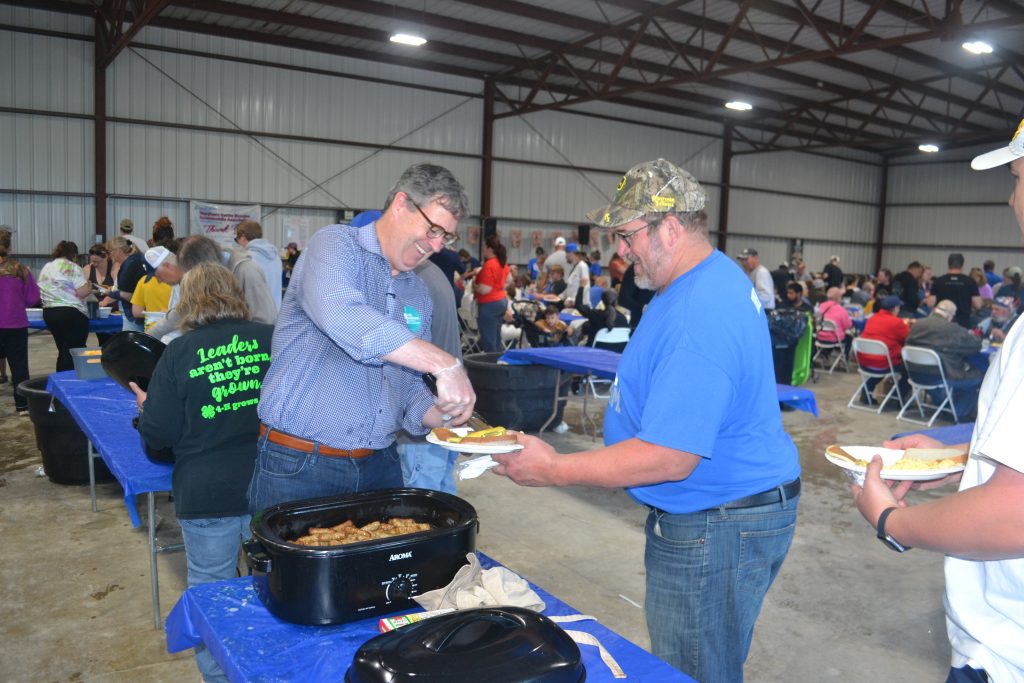 Joel Brennan serves sausage at the Sheboygan County Dairy Breakfast in Sheboygan Falls on Saturday, June 20, 2026. (Photo by Erik Gunn/Wisconsin Examiner)