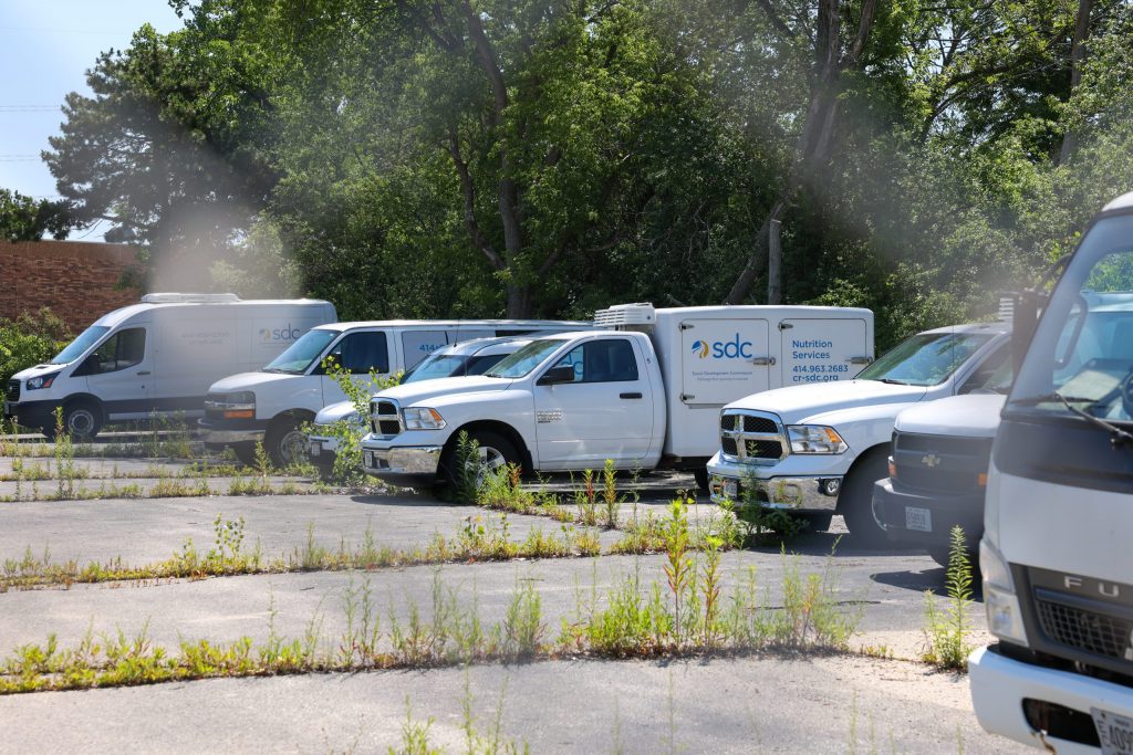 Several vehicles with SDC branding parked in a side lot at an SDC building located at 6850 N. Teutonia Ave. on Tuesday, July 7. (Photo by Jonathan Aguilar / Milwaukee Neighborhood News Service / CatchLight Local)