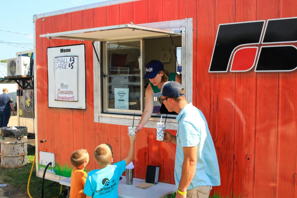 Former Eau Claire Common Council President Emily Berge serves milkshakes out of the Farm Bureau stand at the Trempealeau County Fair. (Photo by Henry Redman | Wisconsin Examiner)