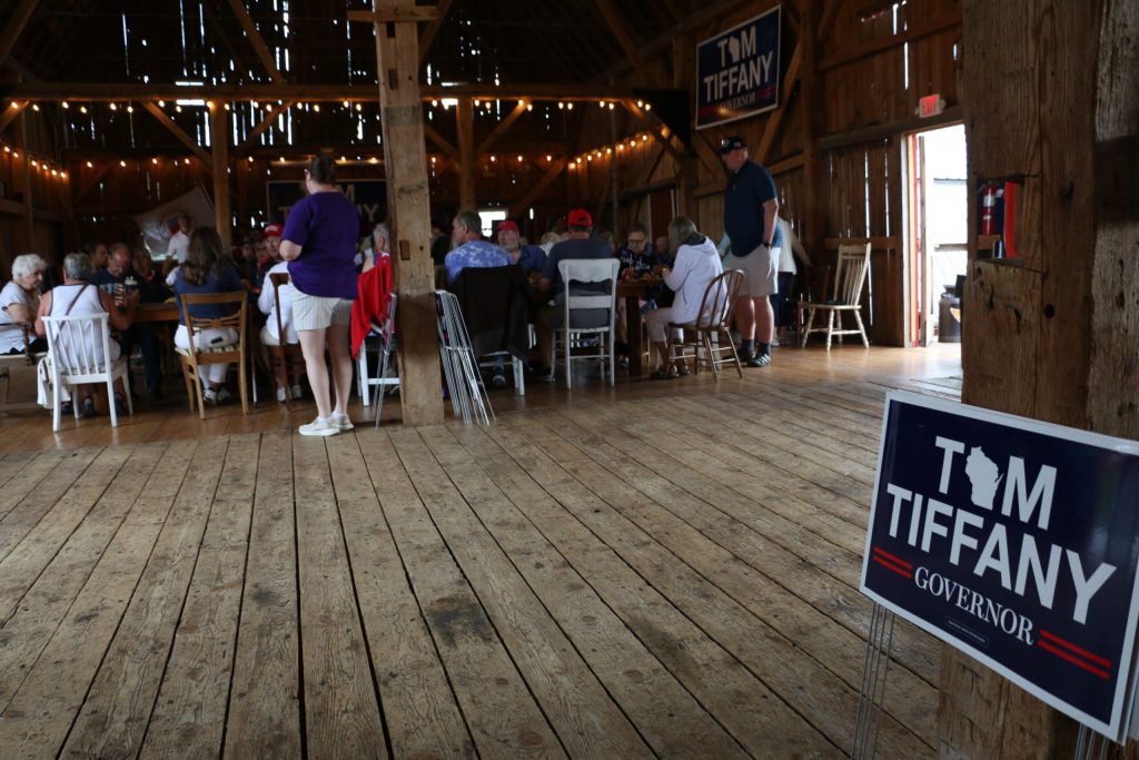 Supporters of Congressman Tom Tiffany’s run for governor tuck into barbecue at a “Freedom Fest” event hosted by his campaign June 28, 2026 at the Elderberry Manor wedding barn in West Bend. Rich Kremer/WPR