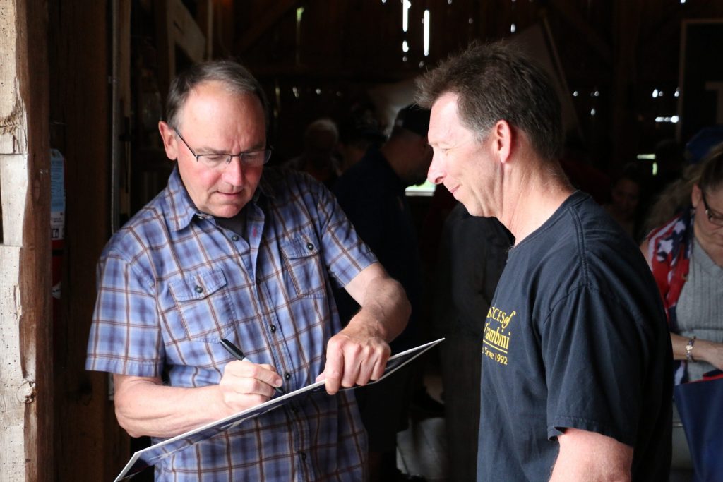 Republican U.S. Rep. Tom Tiffany, who is running for Wisconsin governor, signs the yard sign of a supporter at his campaign’s “Freedom Fest” event on June 28, 2026 at the Elderberry Manor Wedding Barn in West Bend, Wis. Rich Kremer/WPR