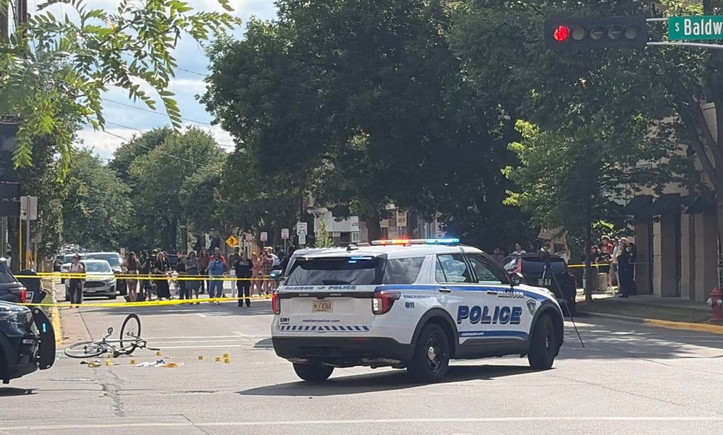 Madison Police officers block the intersection of Williamson Street and S. Baldwin Street in Madison, Wis. after police shot and killed a man on July 22, 2026. Alyssa Allemand/WPR
