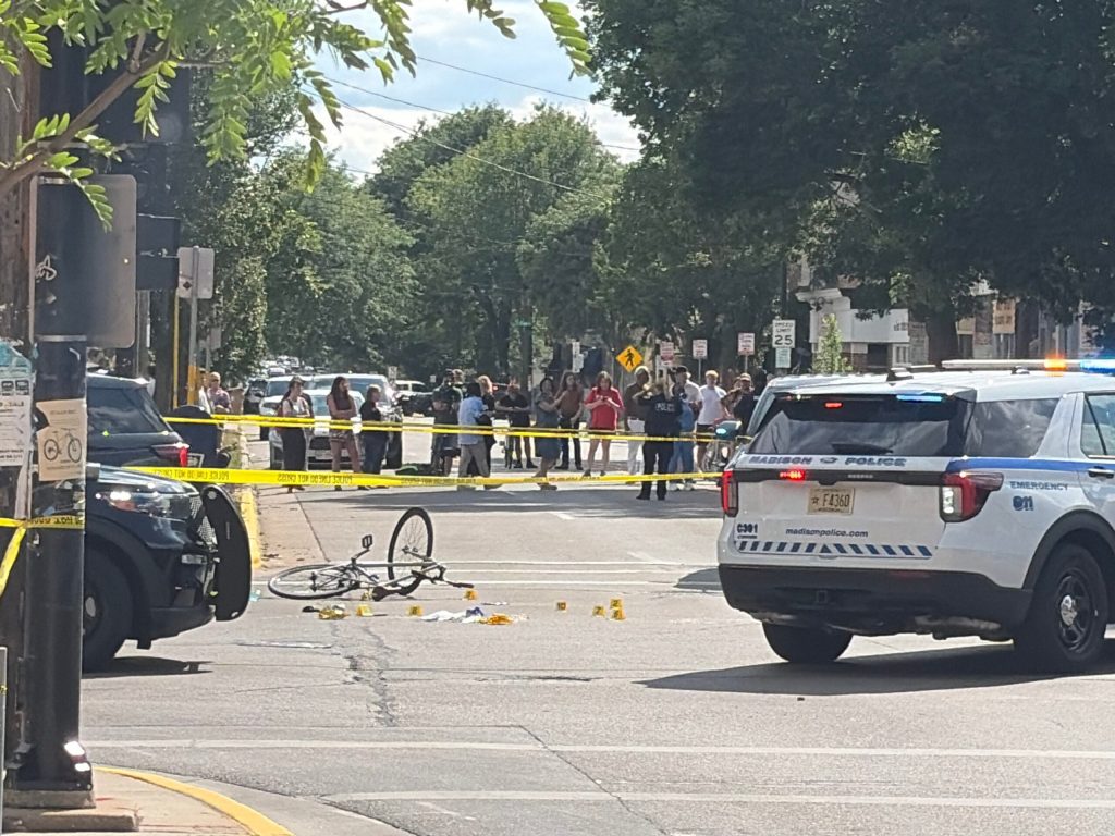 Madison Police officers block the intersection of Williamson Street and S. Baldwin Street in Madison, Wis. after police shot and killed a man on July 22, 2026. Alyssa Allemand/WPR