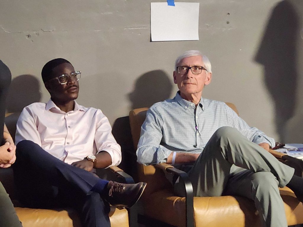 Milwaukee County Executive David Crowley sits next to Gov. Tony Evers during a campaign event in Appleton on Monday, Aug. 3, 2026. Joe Schulz/WPR