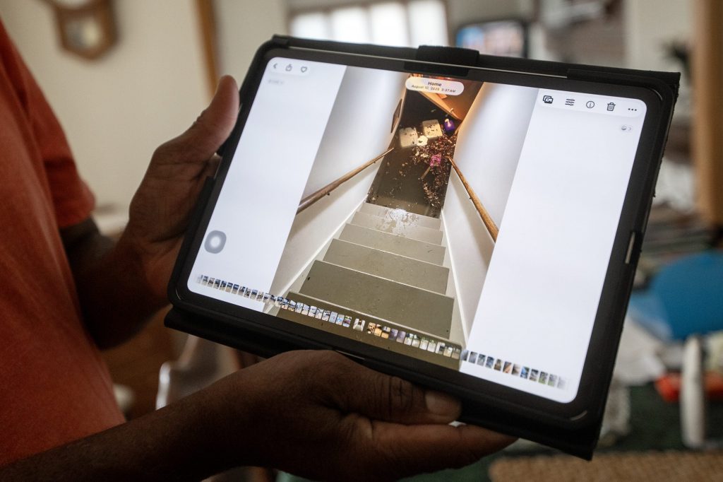 James Moore shows a photo taken in 2025 of flood water creeping up his basement stairs Friday, Aug. 17, 2026, in Wauwatosa, Wis. Angela Major/WPR