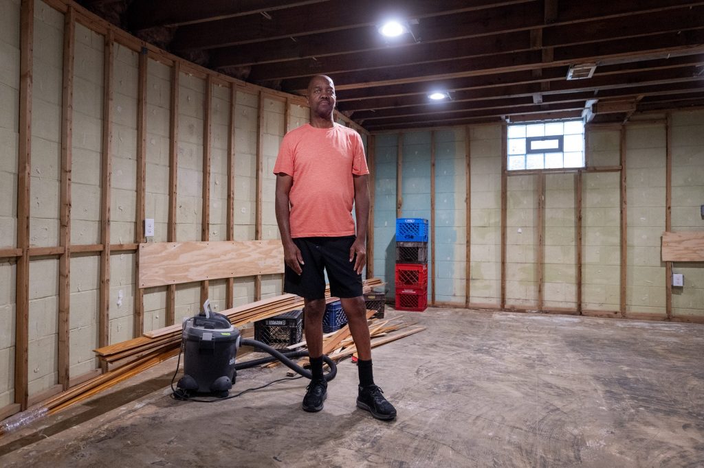 James Moore stands in his basement, which is still undergoing repairs from flood damage, Friday, Aug. 17, 2026, in Wauwatosa, Wis. Angela Major/WPR