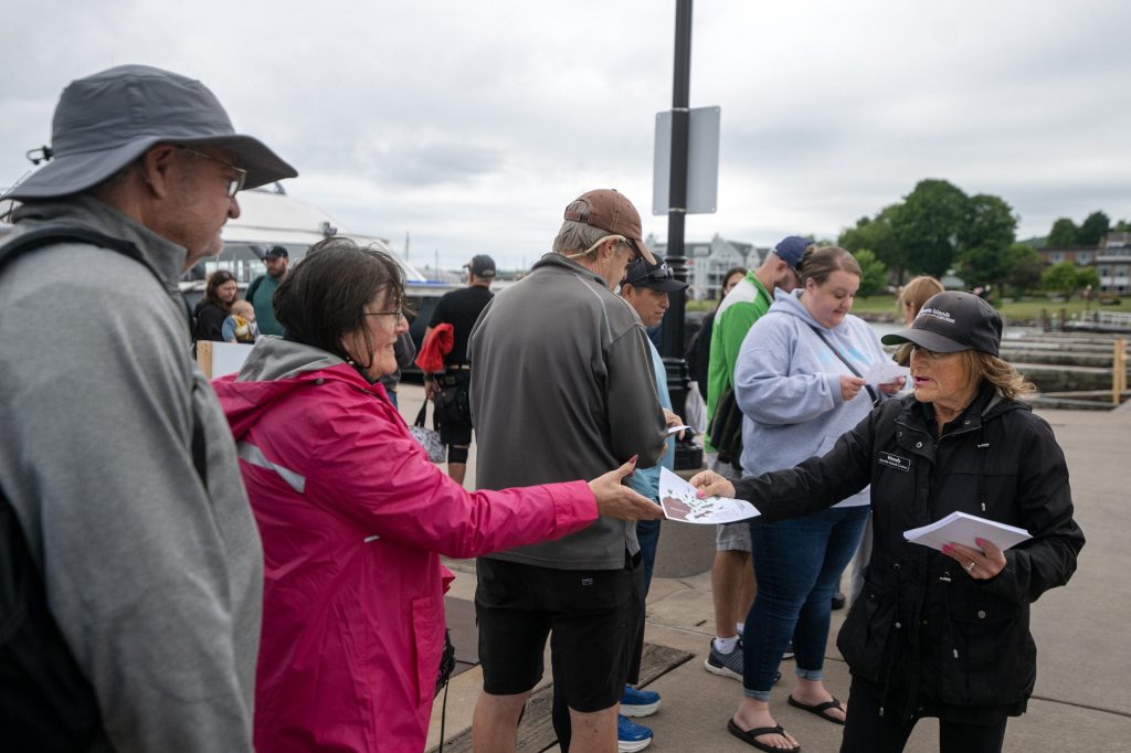 Wendy Young passes out maps and gives an introduction to a cruise to the Apostle Islands on Wednesday, July 8, 2026, in Bayfield, Wis. Angela Major/WPR