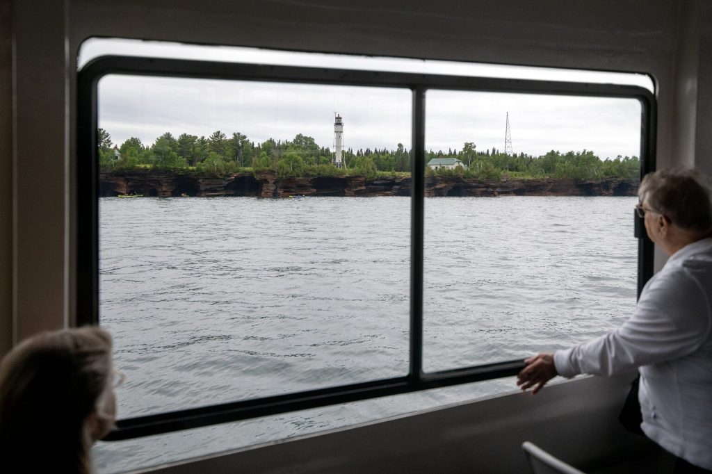 People gaze out of a window as they pass by the Apostle Islands on Wednesday, July 8, 2026, in Bayfield, Wis. Angela Major/WPR