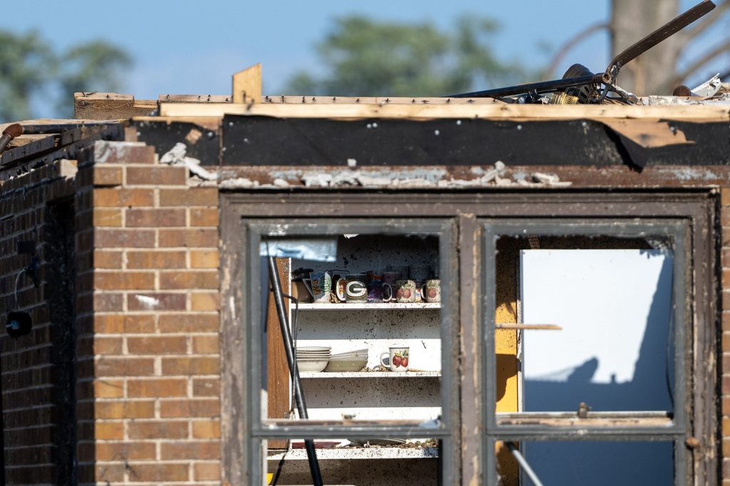 Dishes can be seen inside a kitchen cabinet of a home damaged by a tornado Tuesday, Aug. 25, 2026, in Menasha, Wis. Angela Major/WPR