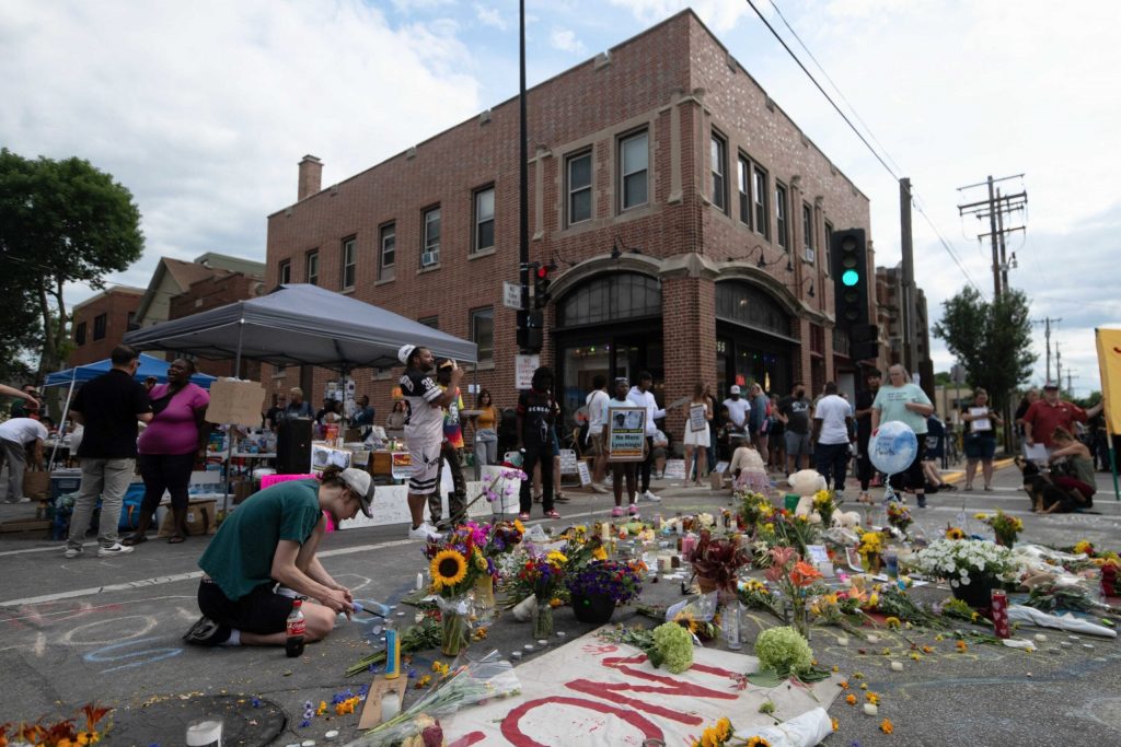 Community members add to a memorial for Corey Ruiz, 38, on July 23, 2026 at the intersection of Williamson Street and S. Baldwin Street Madison, Wis. Ruiz was shot and killed by police on July 22, 2026. Angela Major/WPR