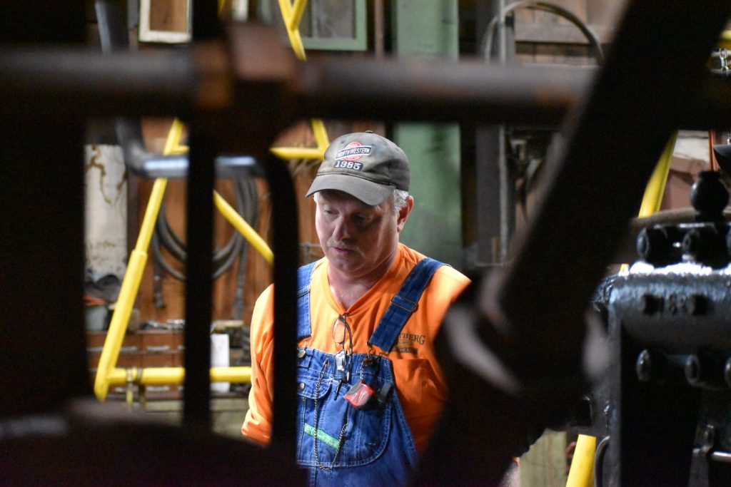 Mike Wald, leading 1385’s restoration, looks at the internal pieces of the steam locomotive. Avery Martinez/WPR