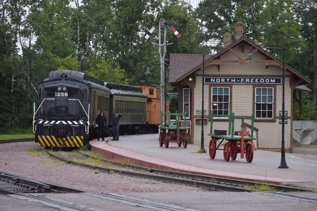 A volunteer rail crew stand beside their train at the Mid-Continent Railway Museum in North Freedom, WI. Avery Marinez/WPR
