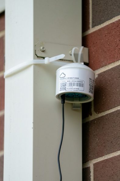 A PurpleAir air quality sensor is installed along a rainspout at Willowbrook Middle School in South Beloit, Illinois. Photographed on Aug. 14, 2026. (Kayla Wolf for Wisconsin Watch)