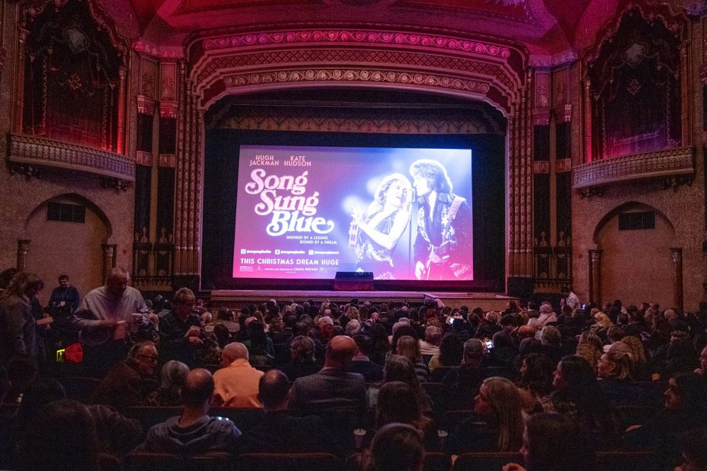 People gather at the Oriental Theatre to watch a premiere of “Song Sung Blue” on Tuesday, Dec. 2, 2025, in Milwaukee, Wis. Angela Major/WPR
