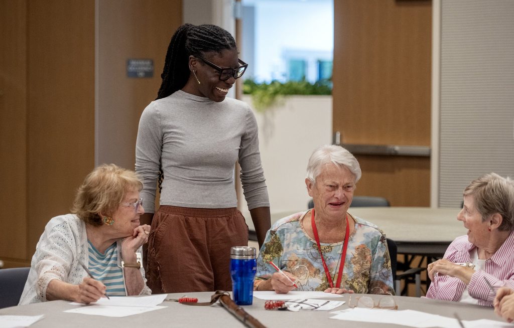 Marquette University PhD student Daija Holliday chats with residents as she leads a brain game activity Saturday, Aug. 22, 2026, at St. Camillus in Milwaukee, Wis. Angela Major/WPR