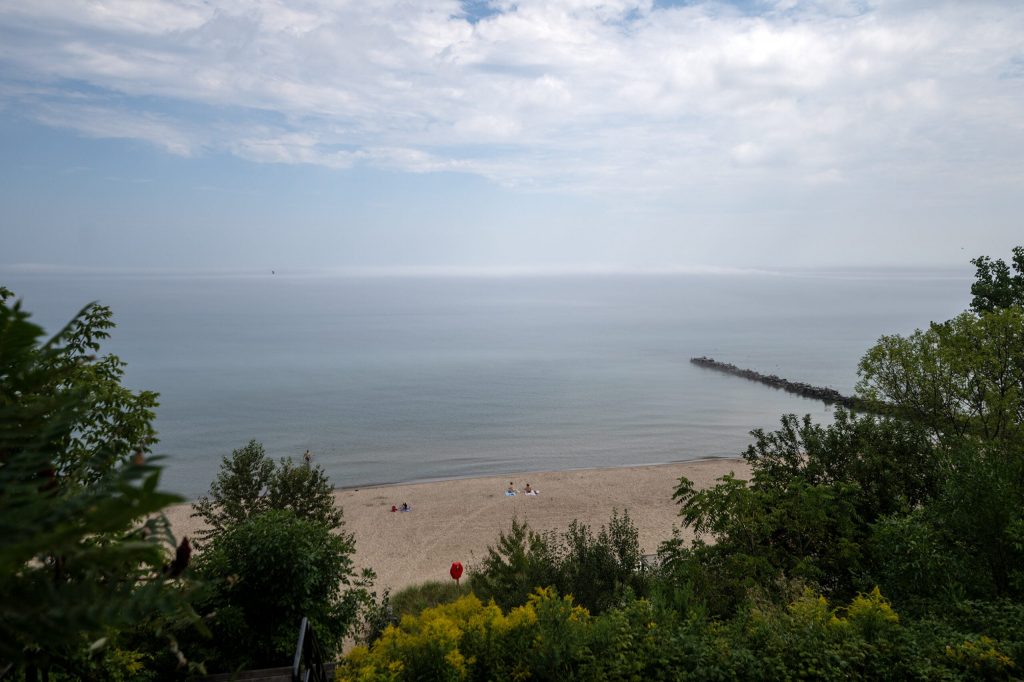 People sit in the sand Tuesday, Sept. 1, 2026, at Atwater Beach in Milwaukee, Wis. Angela Major/WPR