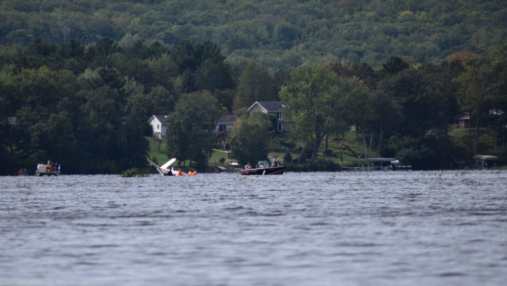 Crews, including the Marathon County Sheriff’s Office Dive Team, connect boats to the waterlogged plane. They’re preparing to pull her across the lake, and back to dry land. Avery Martinez/WPR