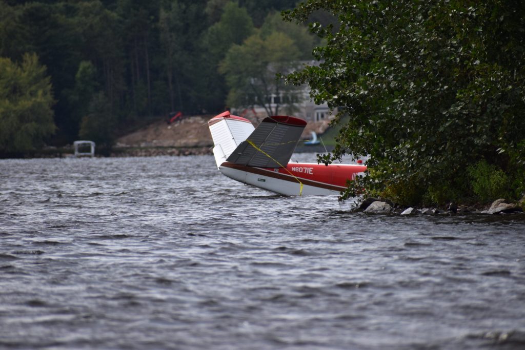 The tail of the plane, covered in caution tape, sits by the shore of Lake Wausau — waiting to be hauled out by a crane. Avery Martinez/WPR