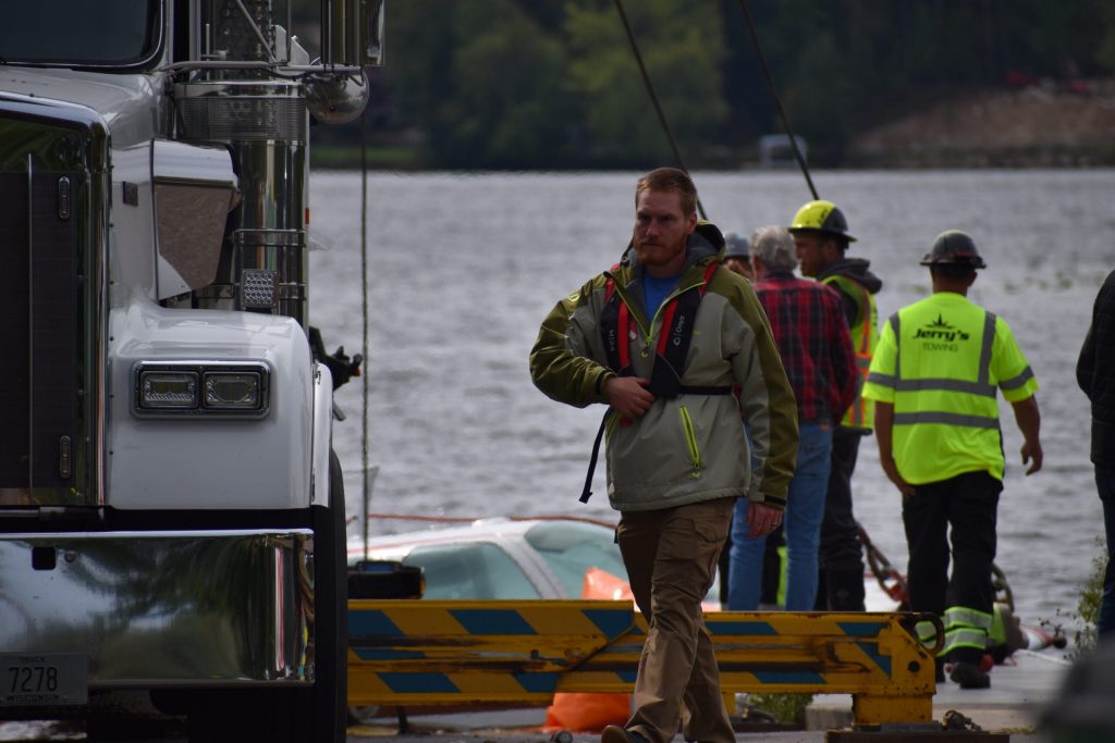 Members of the tow crew, which hauled the plane out on a tow truck, meet with water crews — as different experts take the lead. Avery Martinez/WPR