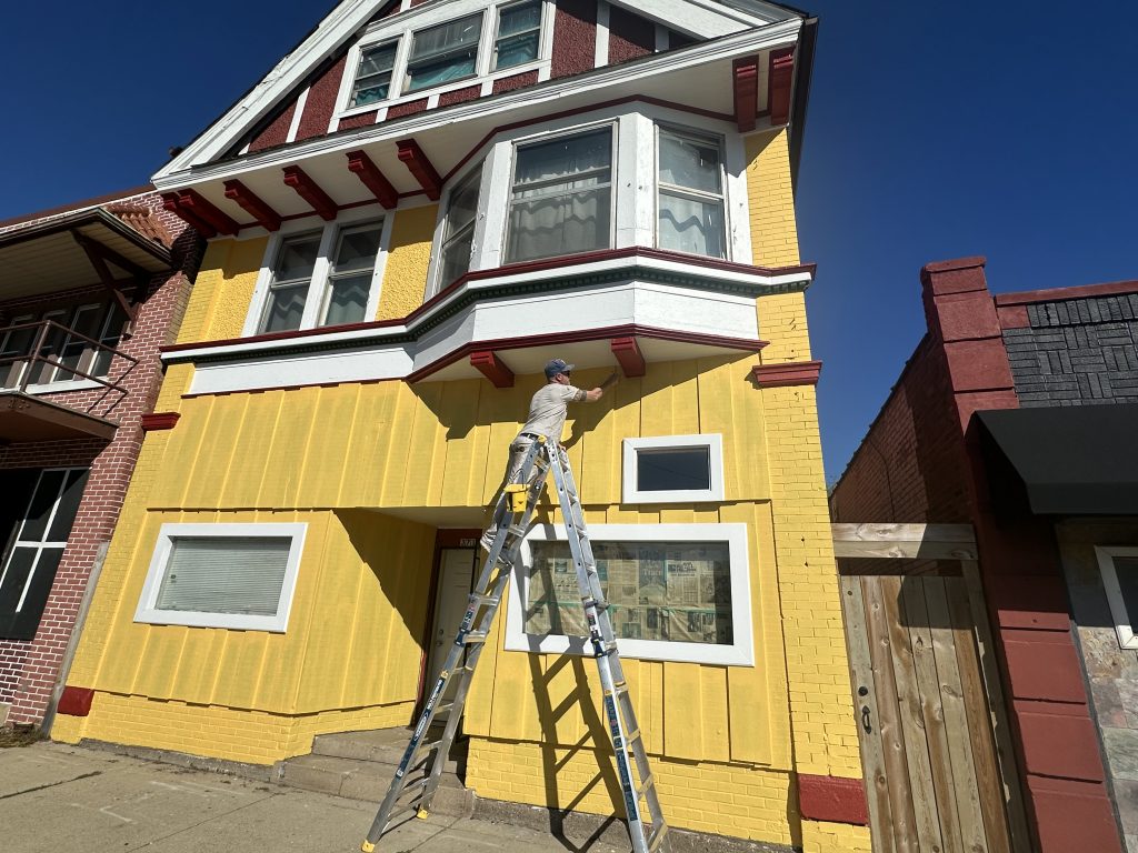 Matt Kuhlman painting the exterior of 3718 W. Vliet St. Photo by Lauren Hafeman on Oct. 5, 2026. 