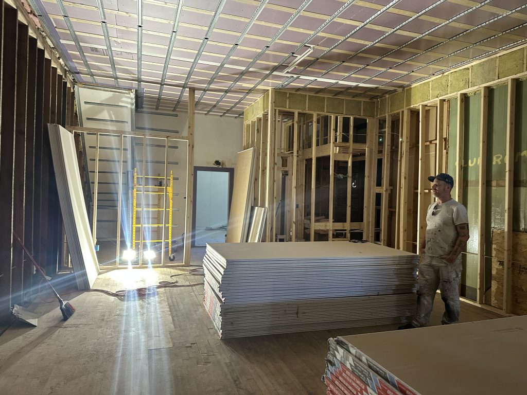 Matt Kuhlman surrounded by Oxbow Projects' drywall prep. Photo by Lauren Hafeman on Oct. 5, 2026. 