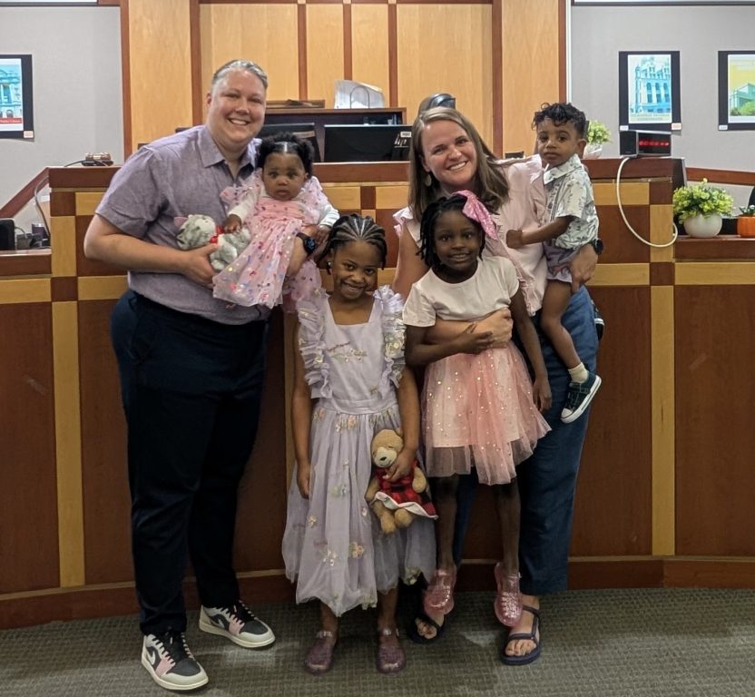 Celia Olson, left, and McKenna Olson pose with their four newly adopted children inside the Milwaukee County Courthouse. (Courtesy of McKenna Olson)
