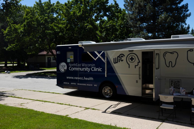 The NorthEast Wisconsin Community Clinic mobile unit is parked across the street from St. John’s Park on June 18, 2026, in Green Bay, Wis. Clinic leaders said 47% of its clients were on Medicaid in 2025. As a result, they are using the mobile unit to educate people about the coming work requirements. (Joe Timmerman / Wisconsin Watch)