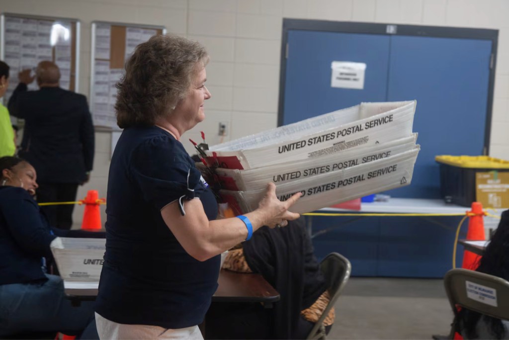 Milwaukee poll workers gather bins of ballots in the August 2026 election. Conspiracy theories circulated after election officials made an error in August, but logs of what happened reveal nothing askew. (Cullen Granzen for Votebeat)