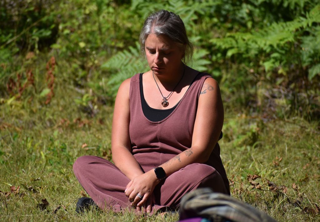 Arbor Vitae resident Beth Soltow relaxes in a clearing as part of a guided walk on the Tara Lila Forest Bathing Trail in Eagle River, Wis. on Aug. 8, 2026. Danielle Kaeding/WPR