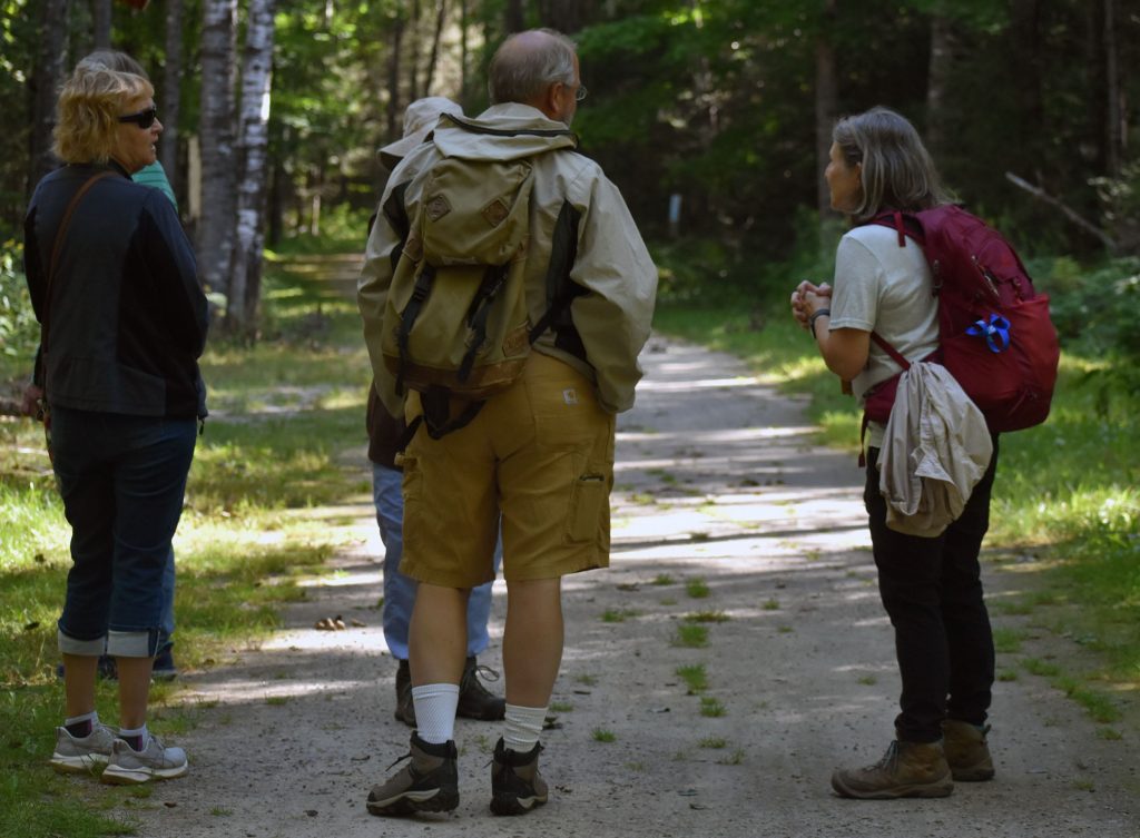 Shelly Rudnick-Peterson (far right) talks with a group that’s gathered at the trailhead of the Tara Lila Forest Bathing Trail in Eagle River, Wis. on Aug. 8, 2026. Danielle Kaeding/WPR