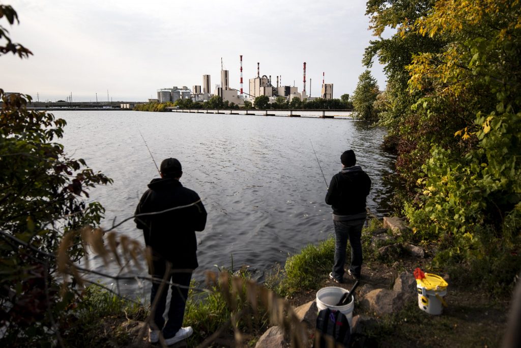 Wisconsin Rapids residents Tanya Plantico, right, and Andy Martinez, left, fish near the Verso paper mill Monday, Sept. 21, 2020. Plantico was surprised when she learned the mill was closing. “It was a huge part of the community,” she said. Angela Major/WPR