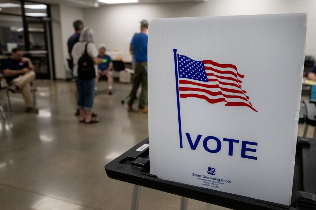 Voters stand in line before filling out a ballot in the partisan primary election Tuesday, Aug. 11, 2026, at Madison East High School in Madison, Wis. Angela Major/WPR