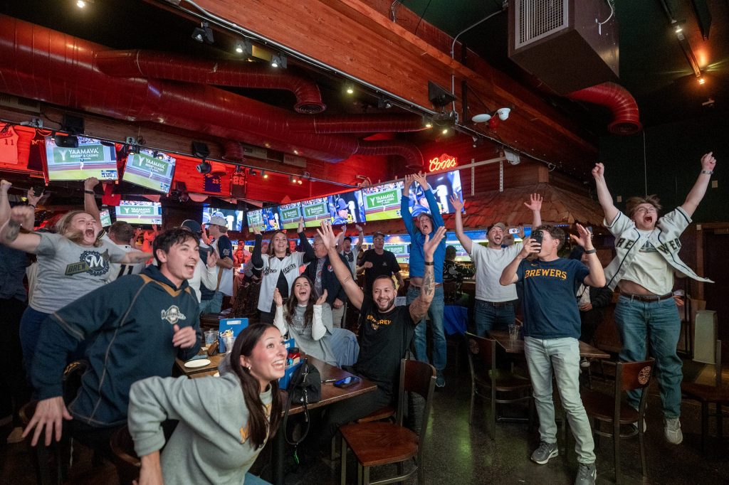 Milwaukee Brewers fans watching from Major Goolsby’s, a Milwaukee bar, react as the team beats the Los Angeles Dodgers to advance to the World Series on Thursday, Oct. 15, 2026, in Milwaukee, Wis. Angela Major/WPR