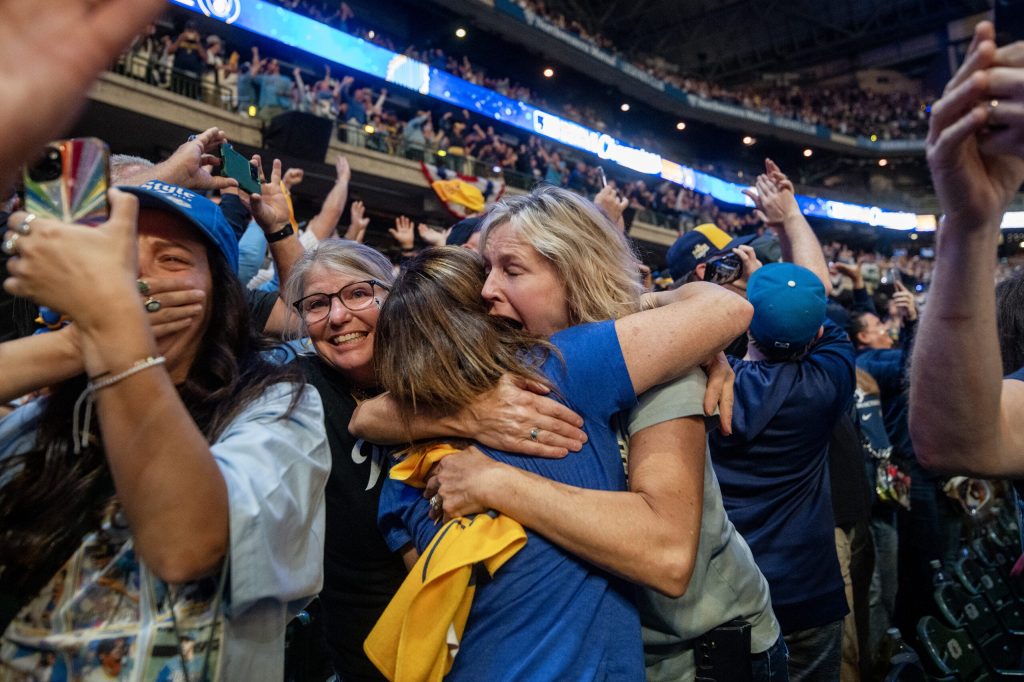 Milwaukee Brewers fans embrace as the team wins the World Series on Wednesday, Oct. 28, 2026, during a watch party at American Family Field in Milwaukee, Wis. Angela Major/WPR