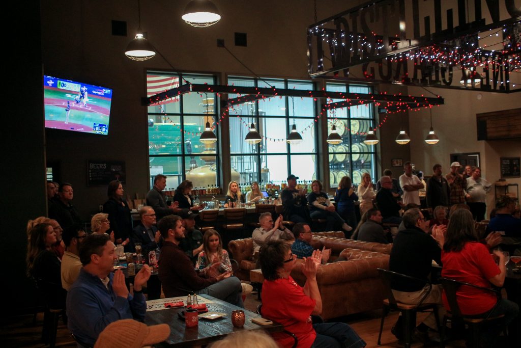 The Milwaukee Brewers play in Game 3 of the World Series in the background of U.S. Rep. Tom Tiffany’s campaign event in New Glarus Oct. 26. (Photo by Henry Redman/Wisconsin Examiner)