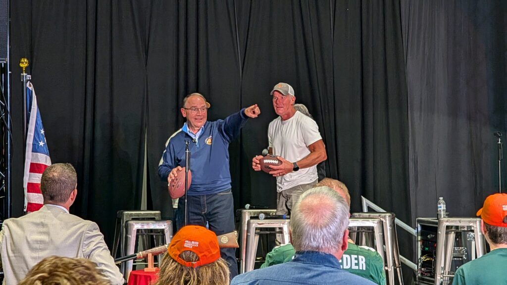 Tom Tiffany throws a signed football into the crowd gathered in Stein's Aircraft Services in Waukesha for the get-out-the-vote rally hosted by Hunter Nation, a national nonprofit for hunters, anglers and outdoor enthusiasts. (Photo by Baylor Spears/Wisconsin Examiner)