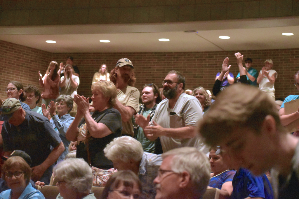 Citizens of Wisconsin Rapids stand up to give a standing ovation for speakers against the data center proposed for the small community in August of 2026. Avery Martinez/WPR